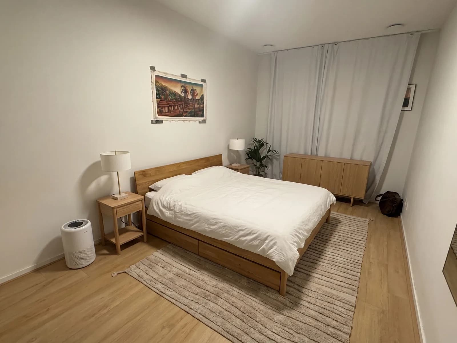 The same bedroom in Japandi style with an oak TONSTAD bed, bedside tables with white lamps, an oak sideboard and a high-pile rug