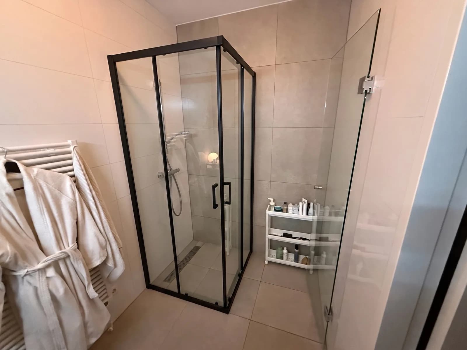 The same bathroom with a square Sklum Brent shower enclosure: clear glass, a matt black frame and two sliding doors, in the shower corner where the glass wall was