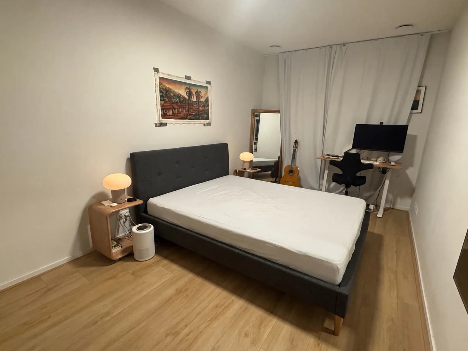 The same bedroom with a dark grey upholstered IKEA IDANÄS bed where the wooden bed was