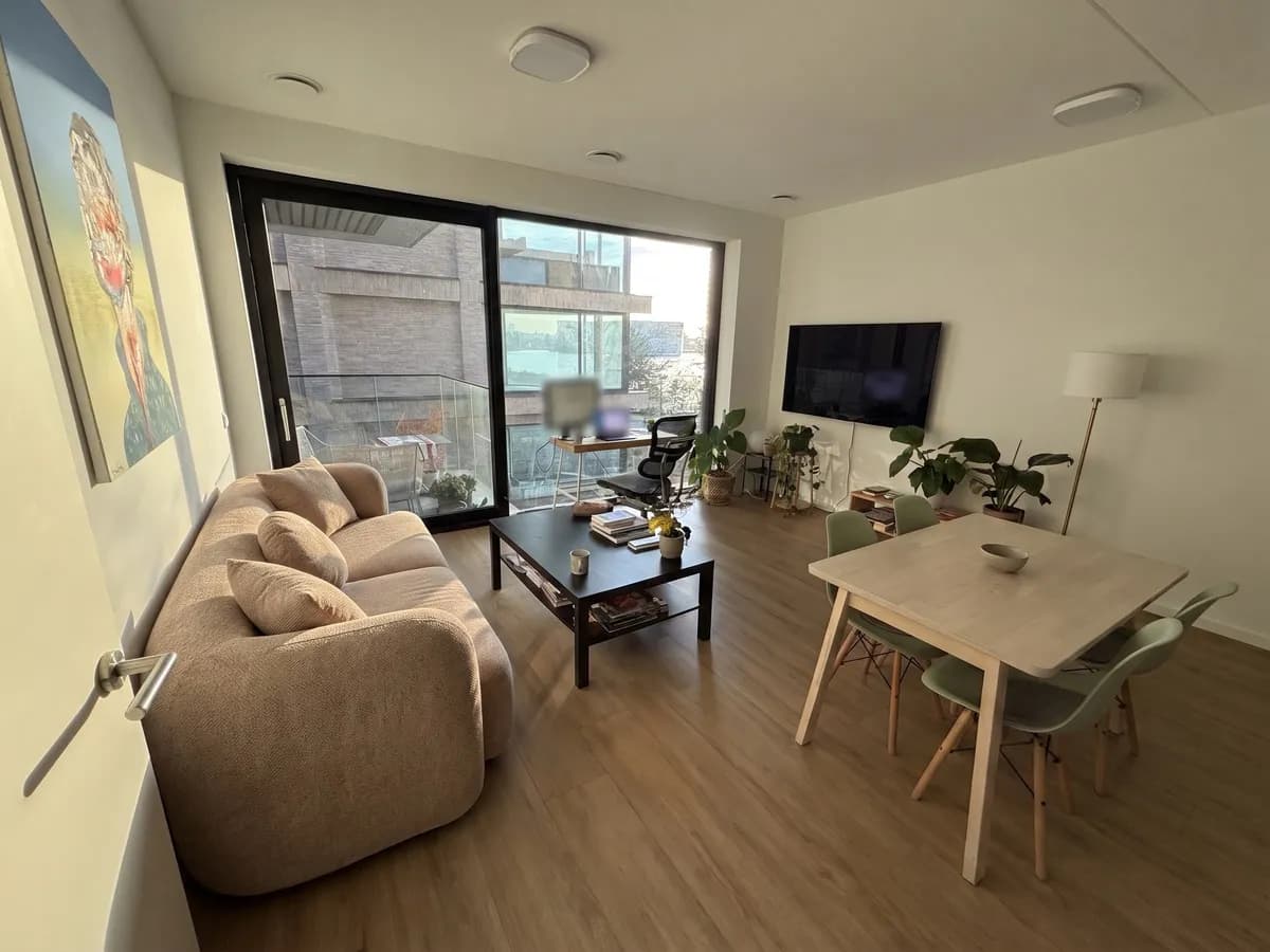 The same living room with a latte-brown chenille Sklum Coco three-seat sofa with rounded arms and cushions, where the sofa bed and side table were
